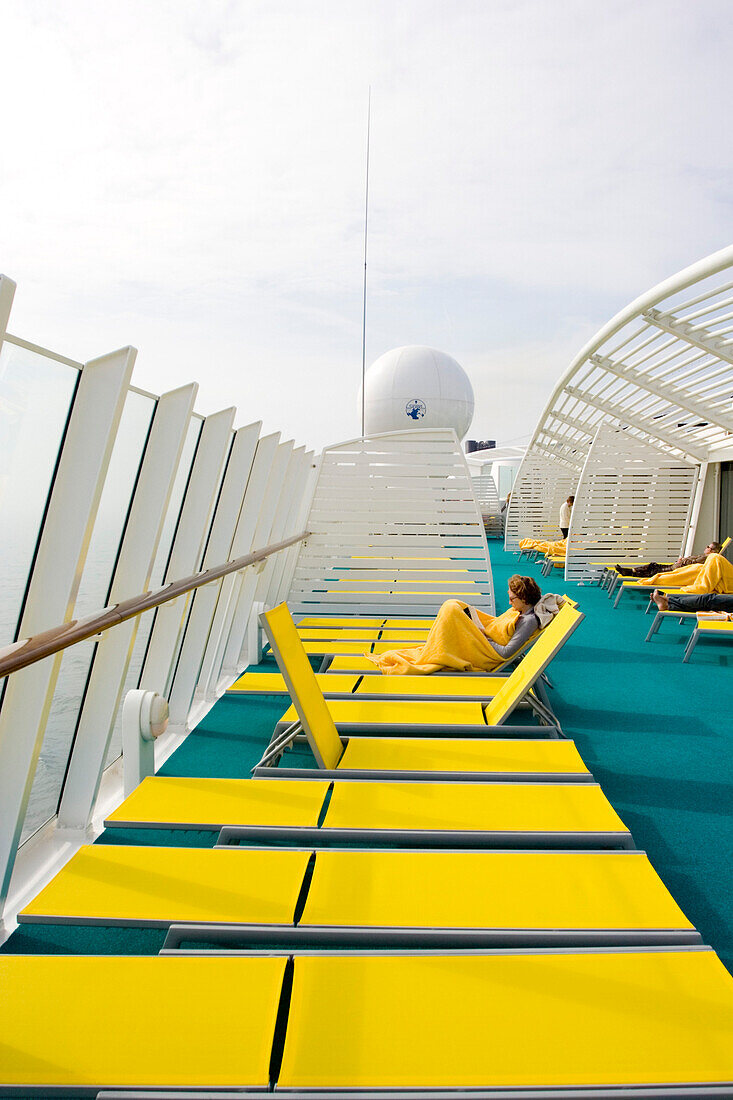 People on yellow sunloungers on cruise ship AidaDiva