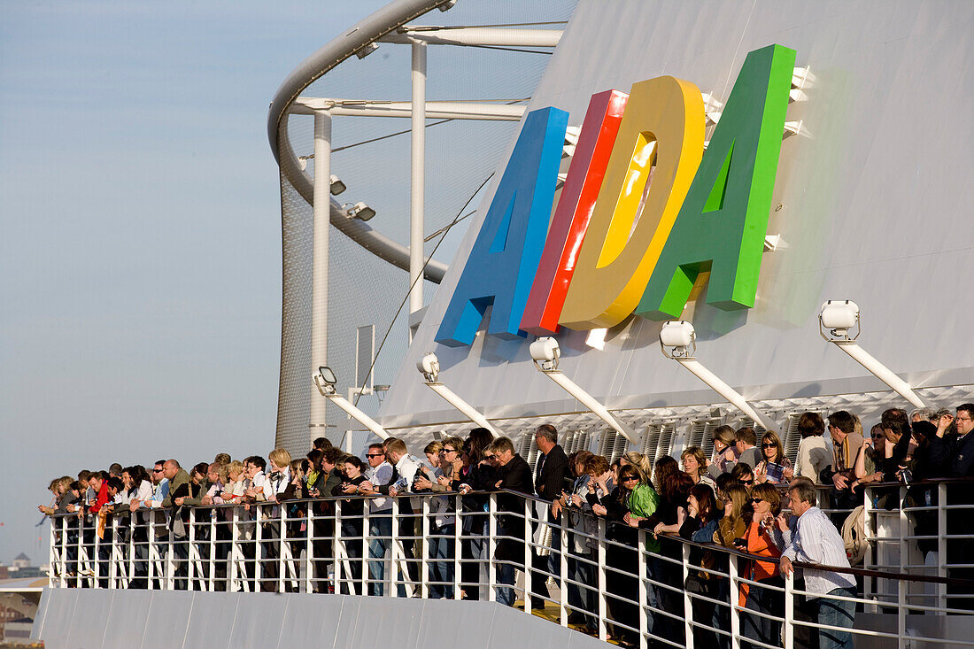 Passengers standing at the railing of cruise ship AidaDiva, Hamburg, Germany