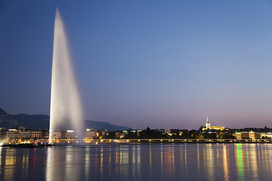 Illuminated Jet d'Eau, one of the largest fountains in the world, and St. Pierre Cathedral at night, Lake Geneva, Geneva, Canton of Geneva, Switzerland