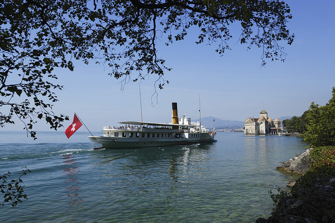 Excursion boat on Lake Geneva arriving Chillon Castle, Veytaux, Vaud, Switzerland