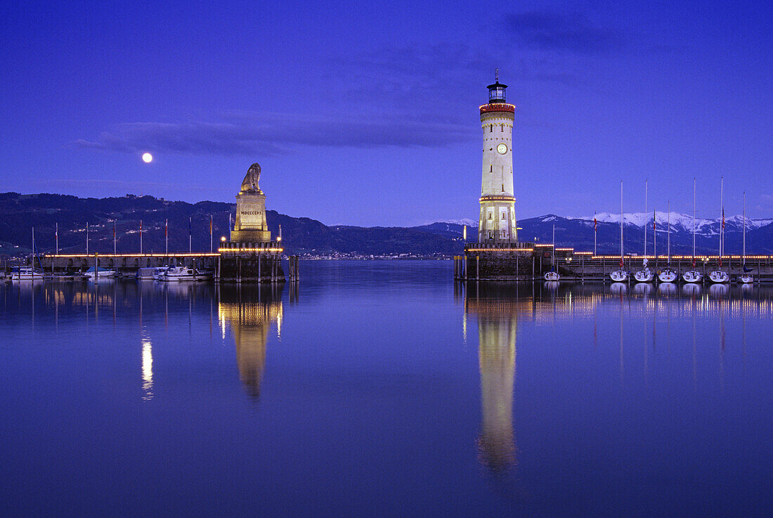 Leuchtturm und Skulptur eines Löwen an der Hafenausfahrt am Abend, Lindau, Bodensee, Baden-Württemberg, Deutschland