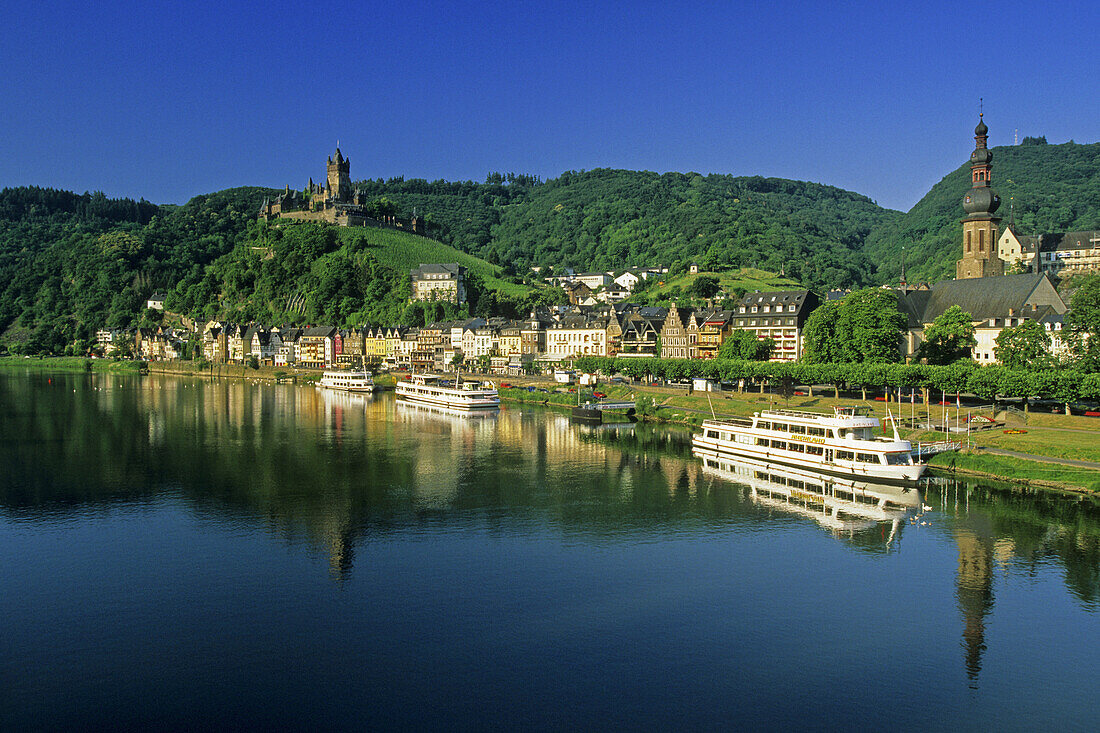 Excursion boats on riverbank, Reichsburg in background, Cochem, Rhineland-Palatinate, Germany