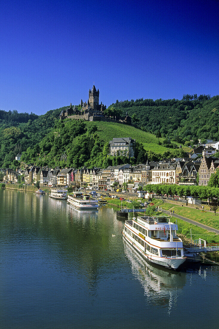 Excursion boats on riverbank, Reichsburg in background, Cochem, Rhineland-Palatinate, Germany