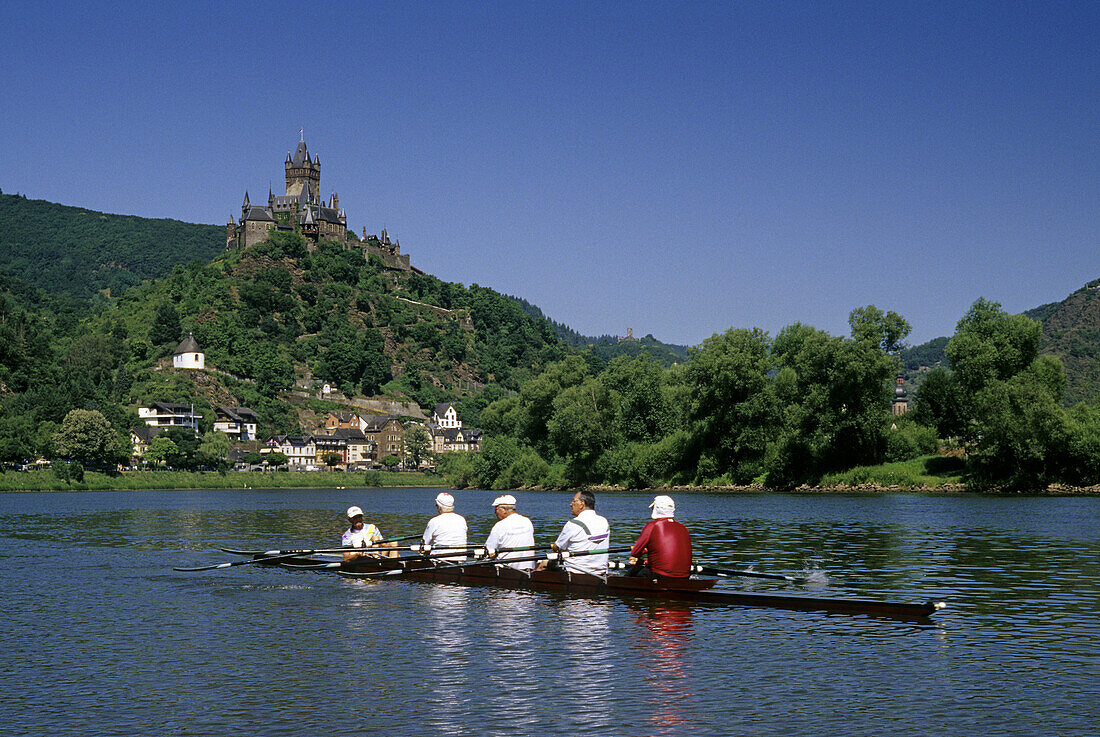 Reichsburg unter blauem Himmel und Ruderboot auf dem Fluss, Mosel, Rheinland-Pfalz, Deutschland