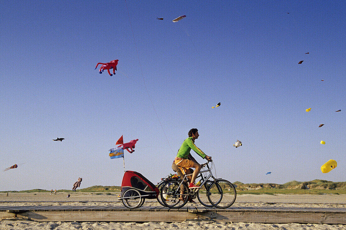 Kites at the beach, cyclists in foreground, St. Peter-Ording, Schleswig-Holstein, Germany