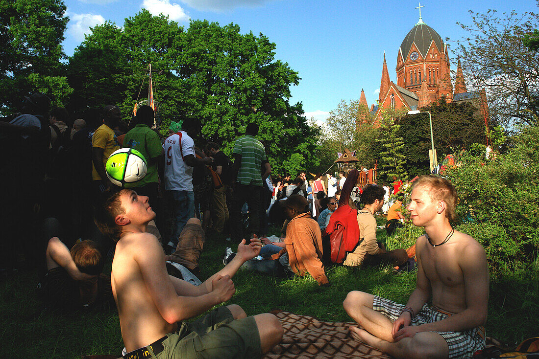 Group of young people sitting in a park near the Holy Cross Church, Berlin, Germany