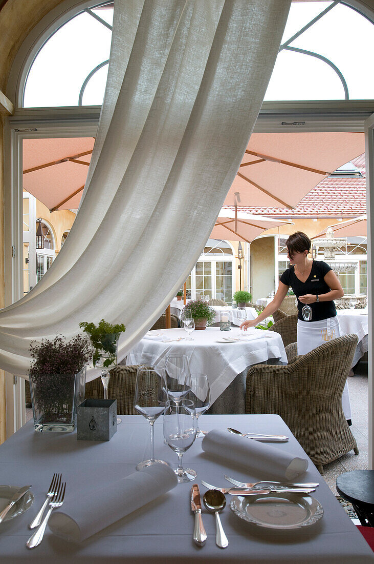 Eine Kellnerin deckt Tische im Restaurant Villino, Lindau, Bodensee, Deutschland