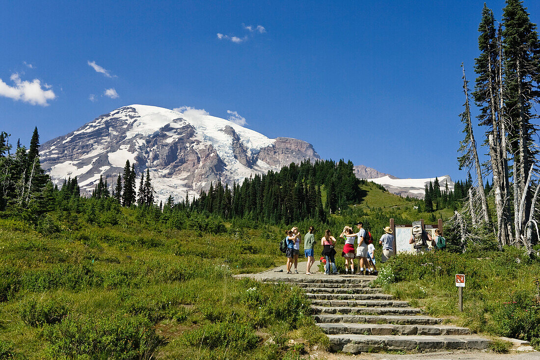 A group of hikers and Mount Rainier under blue sky, Washington, USA
