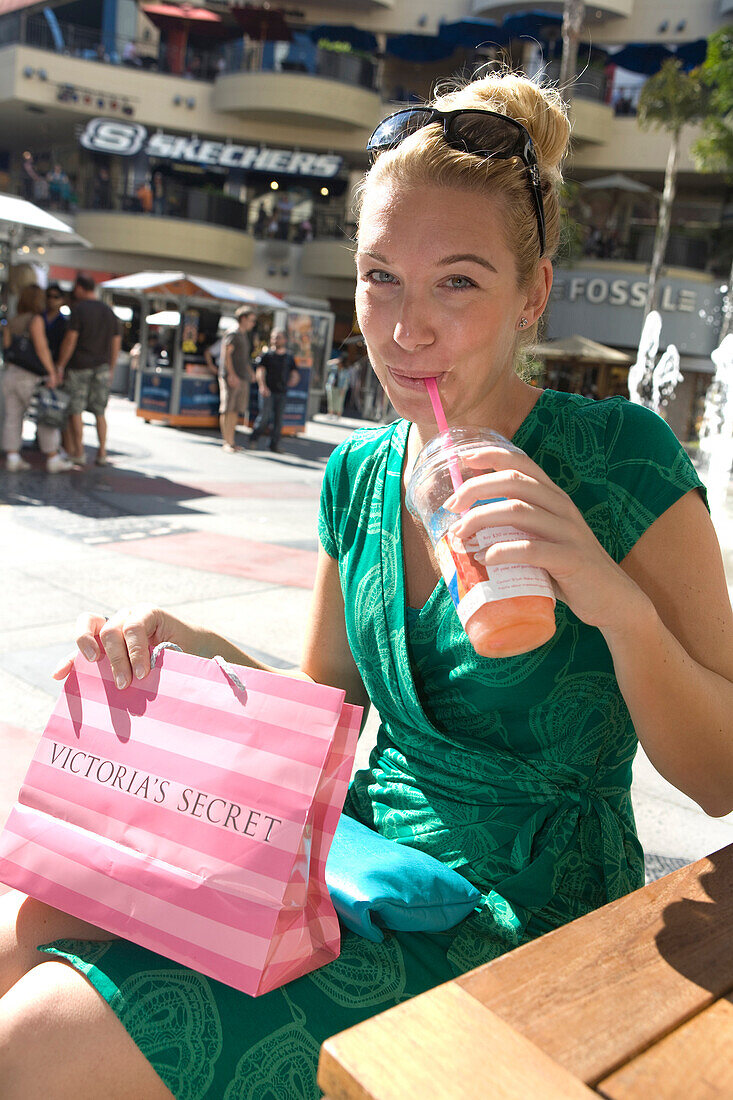Woman enjoying a drink in a cafe after a shopping tour in the Kodak theatre complex, Graumans Chinese Theater, Hollywood, Los Angeles, California, USA