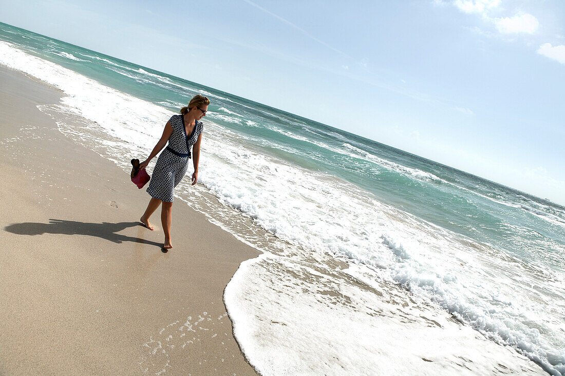 Young woman strolling along the beach, South Beach, Miami Beach, Florida, USA