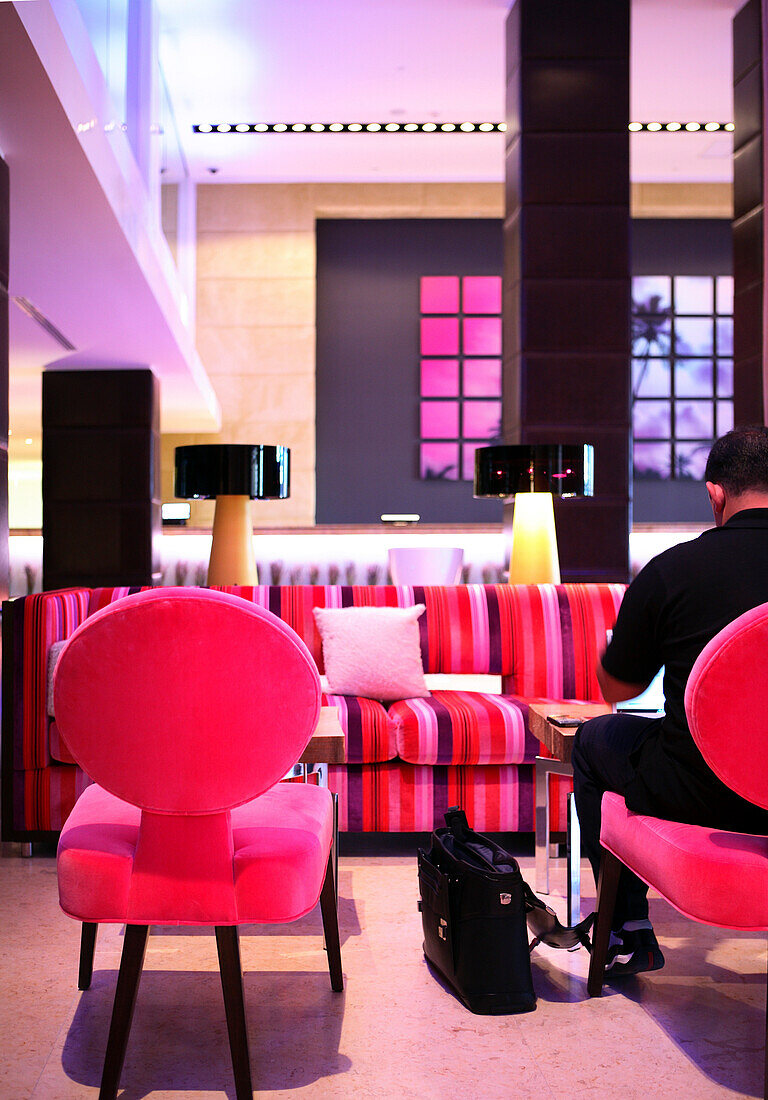 Ein Mann sitzt in der Lobby des Gaansevoort South Hotel, South Beach, Miami Beach, Florida, USA