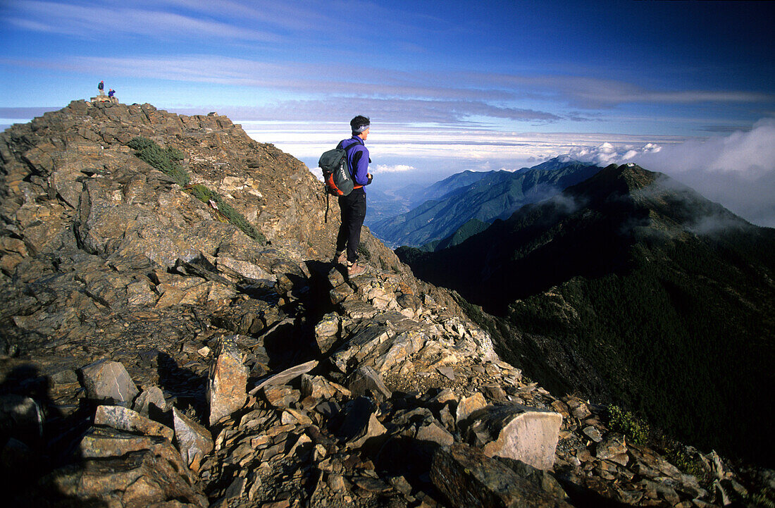 Man looking at view from main peak of Yushan mountain at Yushan National Park, Taiwan, Asia