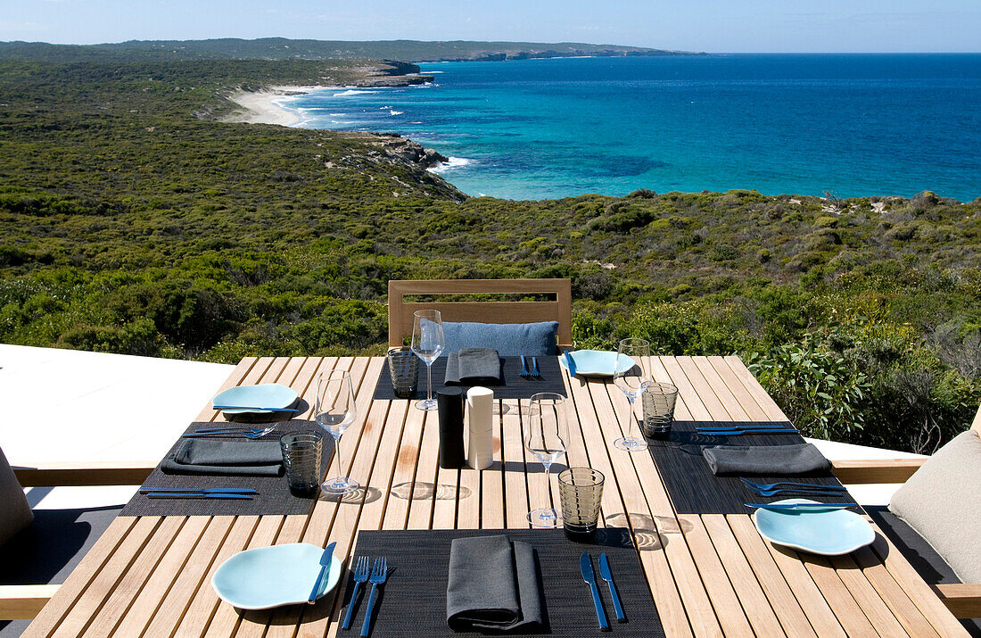 A table is laid on the terrace of the Southern Ocean Lodge with view at Hanson Bay, Kangaroo Island, South Australia, Australia
