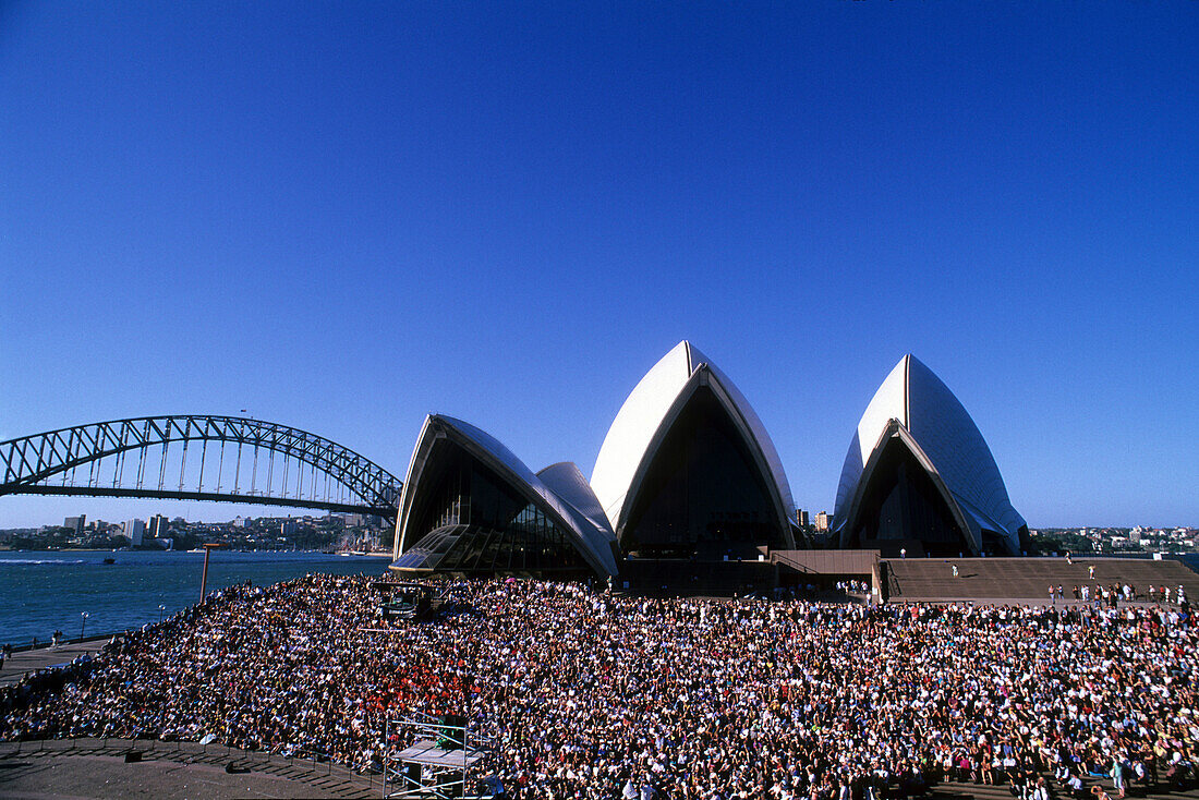 A crowd in front of the Opera House under blue sky, Sydney, New South Wales, Australia