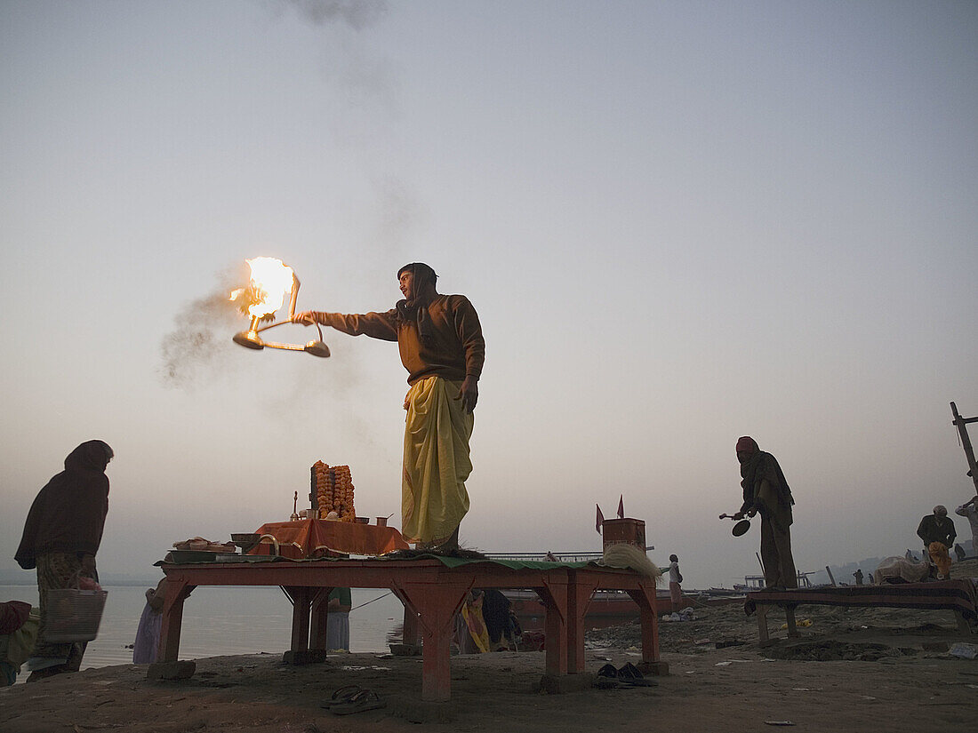 A Hindu priest performs a ritual before sunrise on the bank of the Ganga river in Varanasi, India, a sacred Hindu pilgrimage site.