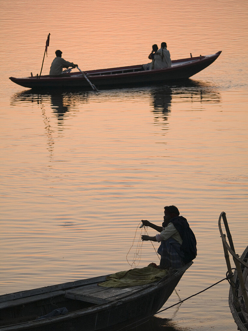 Boats with pilgrims and tourists at dawn in Varanasi, India, a sacred Hindu pilgrimage site.