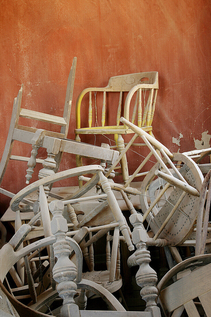 Atop a pile of chairs sits a yellow chair in the back room of the Bodie mortuary, CA, USA