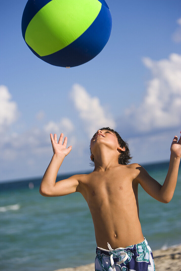 Boy playing with ball at the beach, Hollywood, Florida, USA