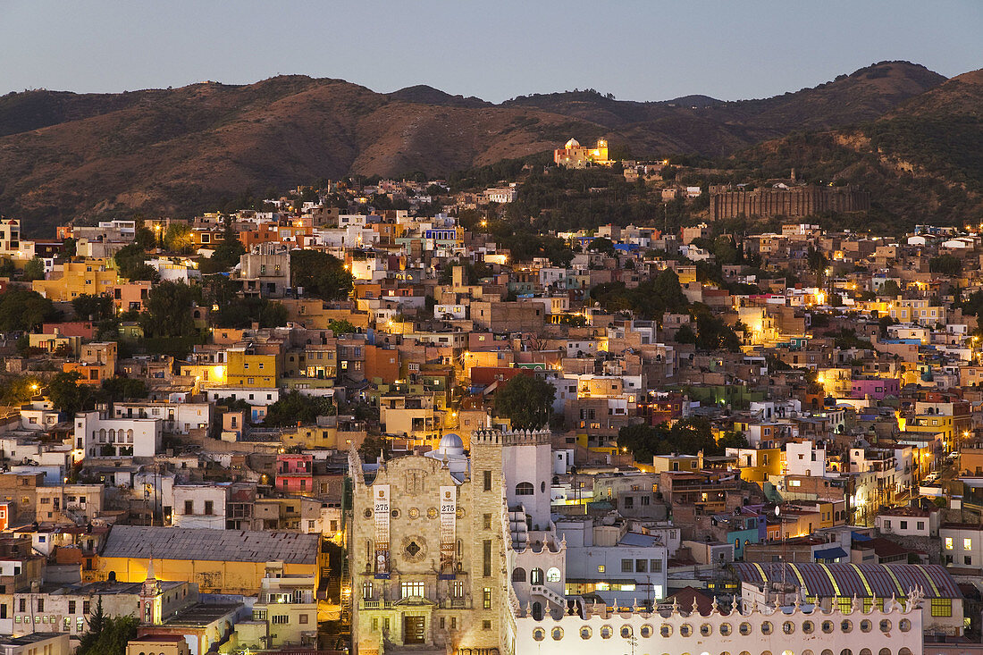 Overview of city at dusk, view from El Pipila monument, university building and churches spread in valley  Guanajuato, Mexico