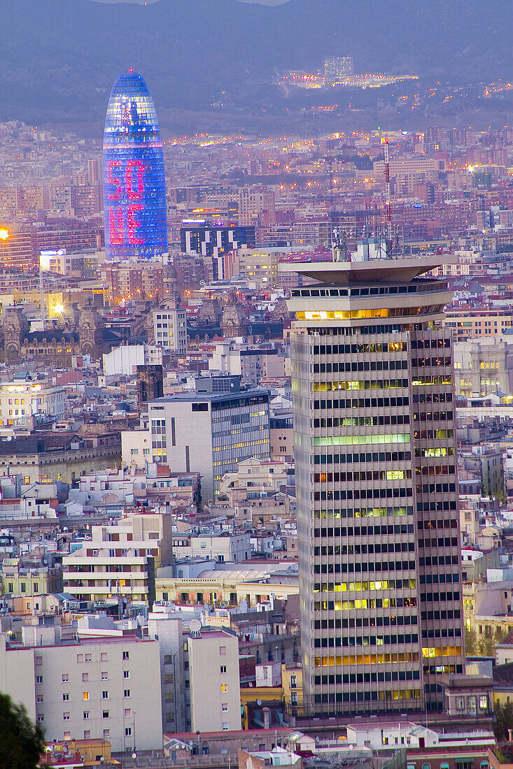 View of Barcelona at dusk with the Torre Colom in the foreground and Agbar Tower by architech Jean Nouvel at the background. Barcelona. Spain