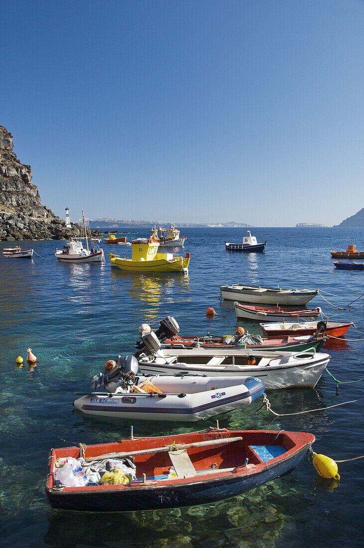 Colorful fishing boats in Ammoudi Bay near Oia Thira, on the Greek Island of Santorini, Greece.