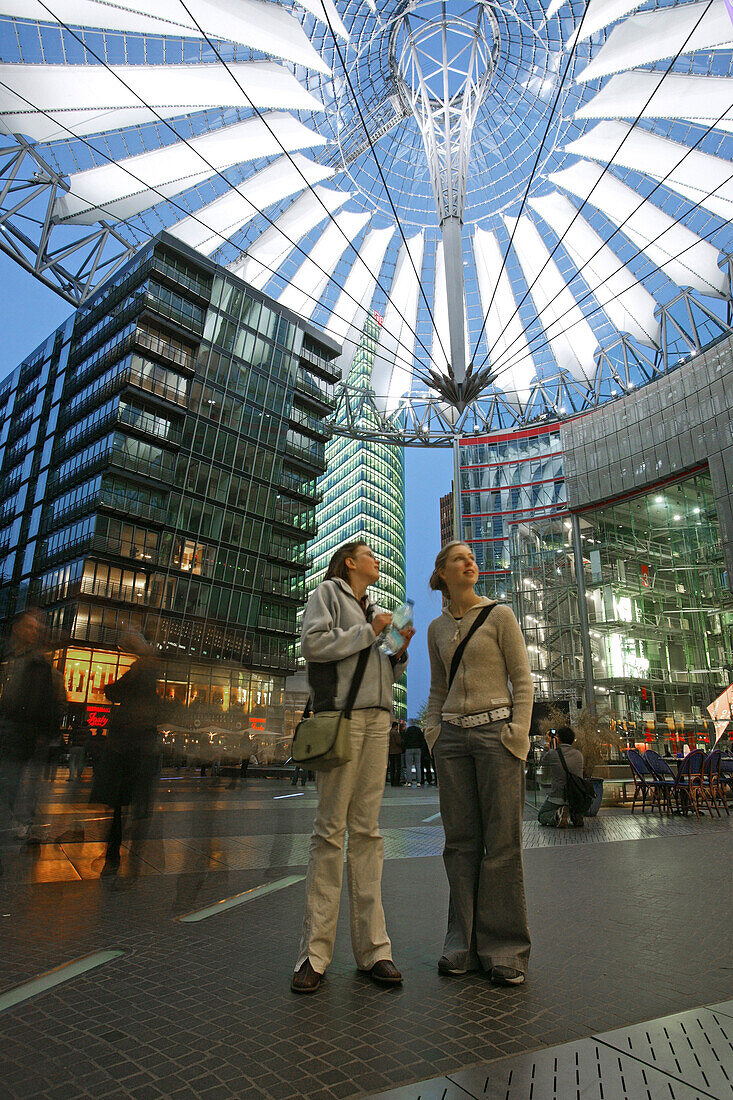 Touristen stehen am Abend unter der Kuppel des Sony Center am Potsdamer Platz, Berlin, Deutschland, Europa