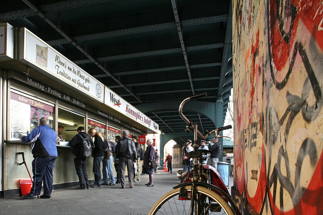 Menschen stehen vor einem Imbiss unter einer Brücke, Schönhäuser Allee, Berlin, Deutschland, Europa