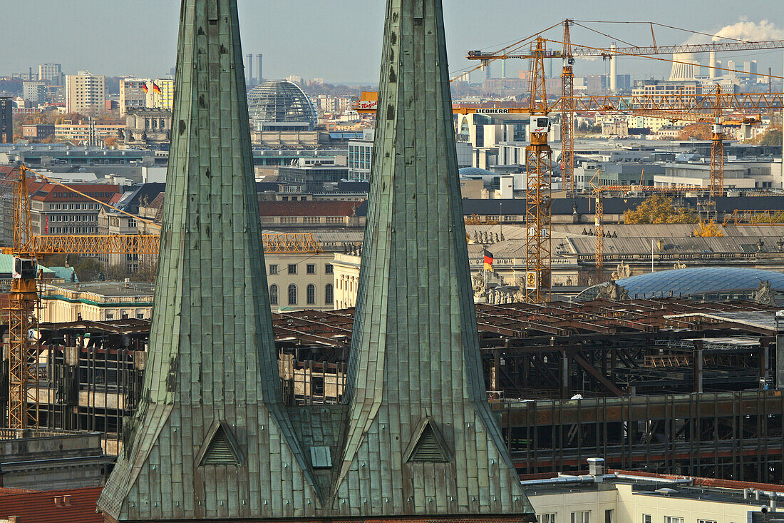 The steeples of St. Nicholas' Church and building cranes in front of Berlin's roofs, Berlin, Germany, Europe