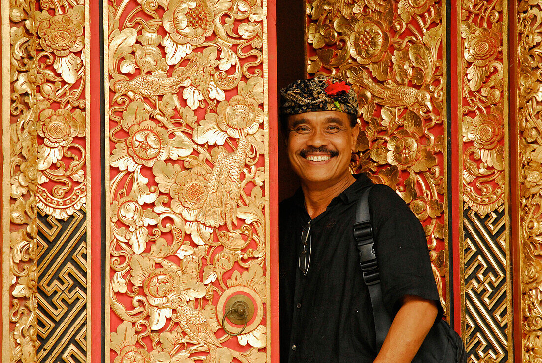 Lachender Mann an handgschnitzer Tür an seinem ARMA Museum, Ubud, Indonesien, Asien