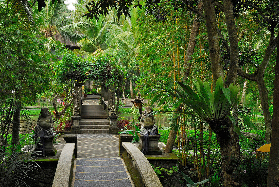 Palmen und Steinfiguren im Garten des ARMA Museum, Ubud, Indonesien, Asien