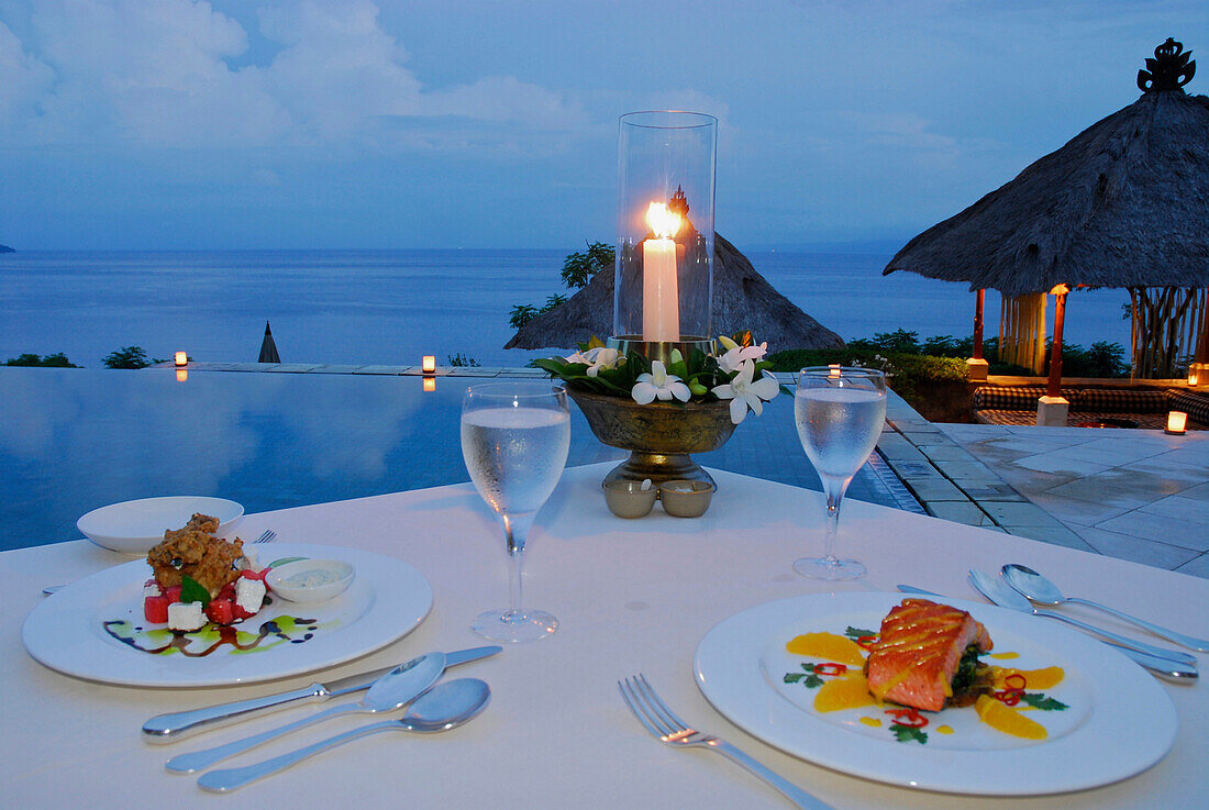 Gedeckter Tisch am Pool im Amankila Resort am Abend, Candi Dasa, Ost Bali, Indonesien, Asien