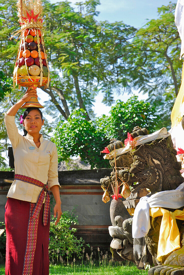 Young woman bringing oblation to the temple of the hotel, Nusa Dua Beach Hotel, Nusa Dua, Bali, Indonesia, Asia