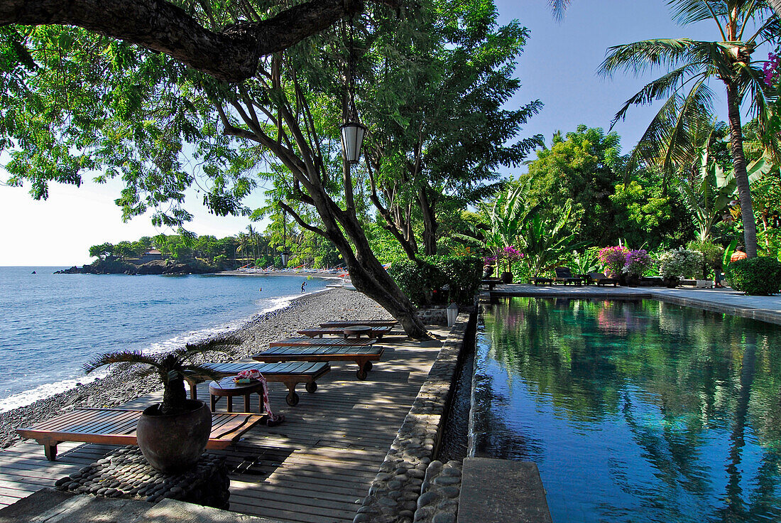 Deserted pool under palm trees at the beach, Mimpi Resort at Tulamben, North East Bali, Indonesia, Asia