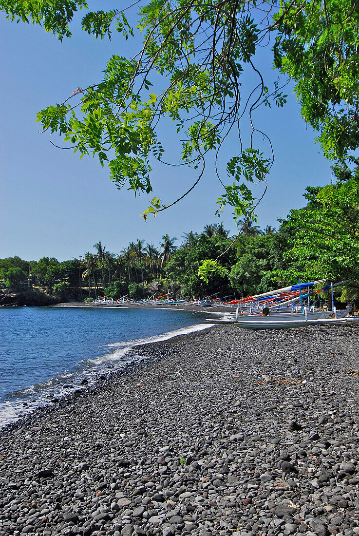 Boats lying on a stony beach under blue sky, Tulamben, East Bali, Indonesia, Asia