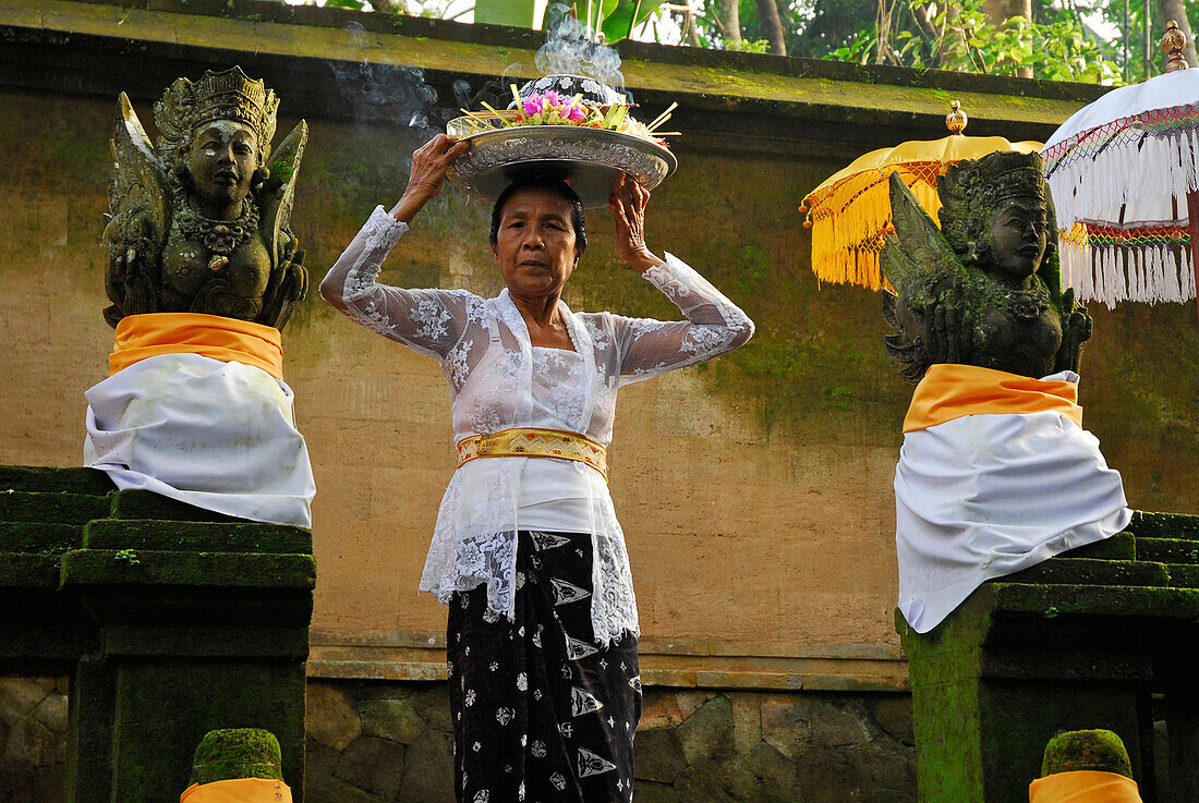 Ältere Frau bringt Opfergabe zum Schrein des Amandari Hotel, Yeh Agung, Bali, Indonesien, Asien