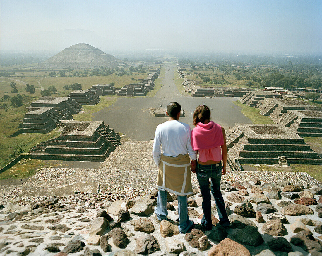 Young couple on top of moon pyramid, view at street of the dead, temple complex Teotihuacan, Mexico, America