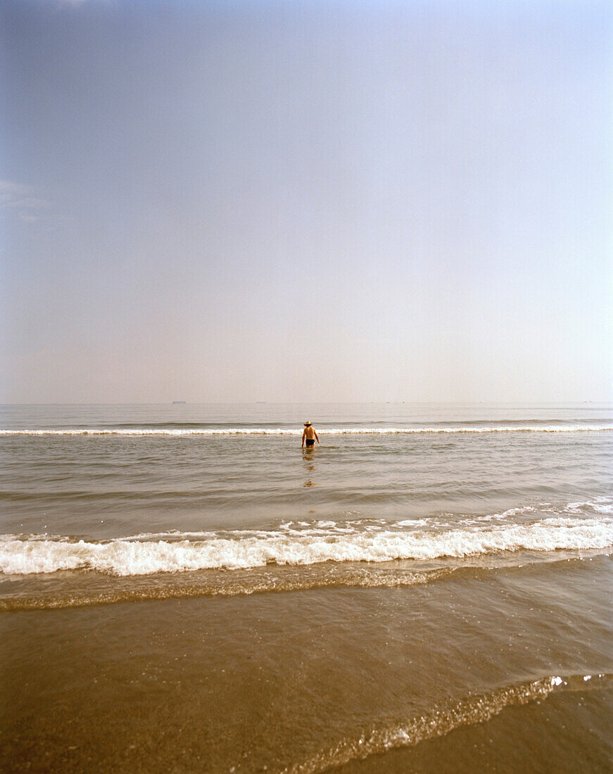 A man going into the sea for a bath, Playa Boca del Rio, Veracruz, Veracruz province, Mexico, America