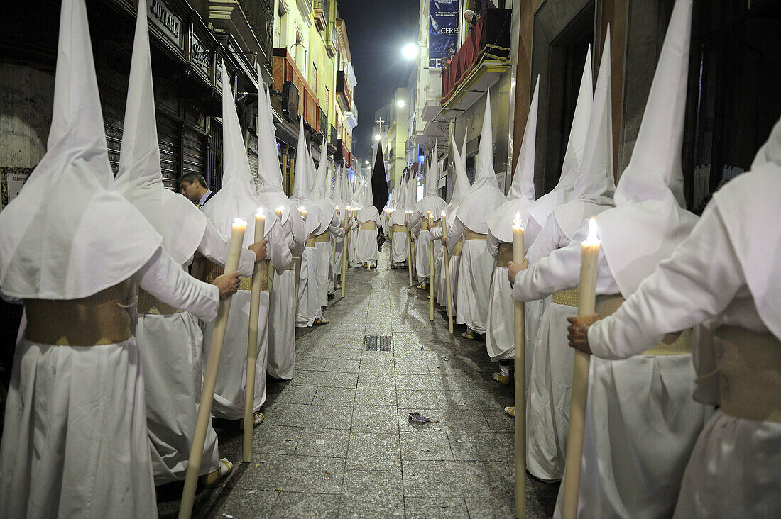 Adult, Adults, Andalucia, Andalusia, Candle, Candles, Carry, Carrying, Catholicism, cities, city, Color, Colour, Europe, exterior, Faith, folk, folklore, Hold, Holding, Holy Week, Hood, Hooded, Hoods, human, Line, Lines, Lit, Night, Nighttime, outdoor, ou