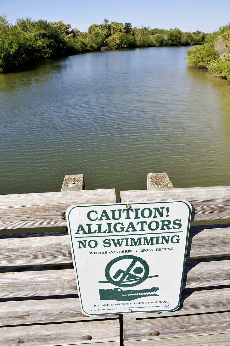 Caution Alligators no swimming sign at Lovers Key State Park Recreation Area Bonita Springs Florida