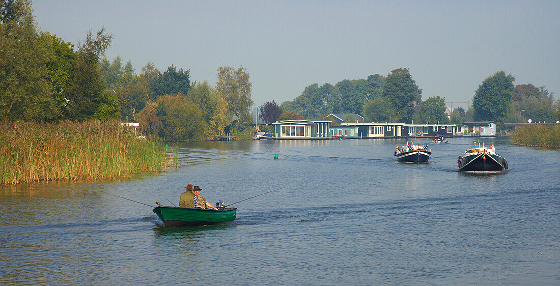 Anglers in a rowing boat and houseboats on the river Vecht, Netherlands, Europe