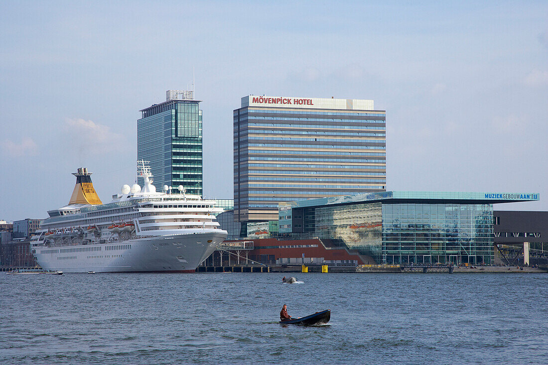 Kreuzfahrtschiff auf dem Fluss Het Ij neben Hochhäusern, Amsterdam, Niederlande, Europa