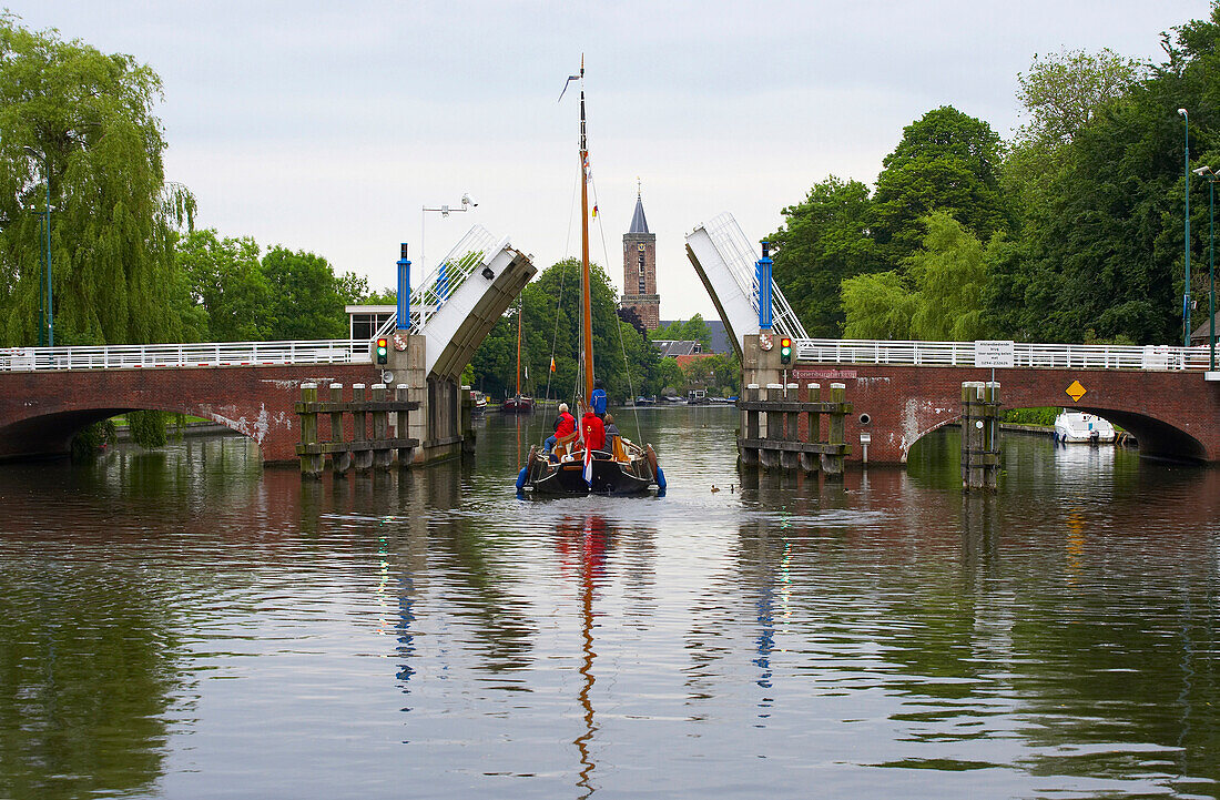 A sailing boat on the river Vecht driving past a bascule bridge, Netherlands, Europe