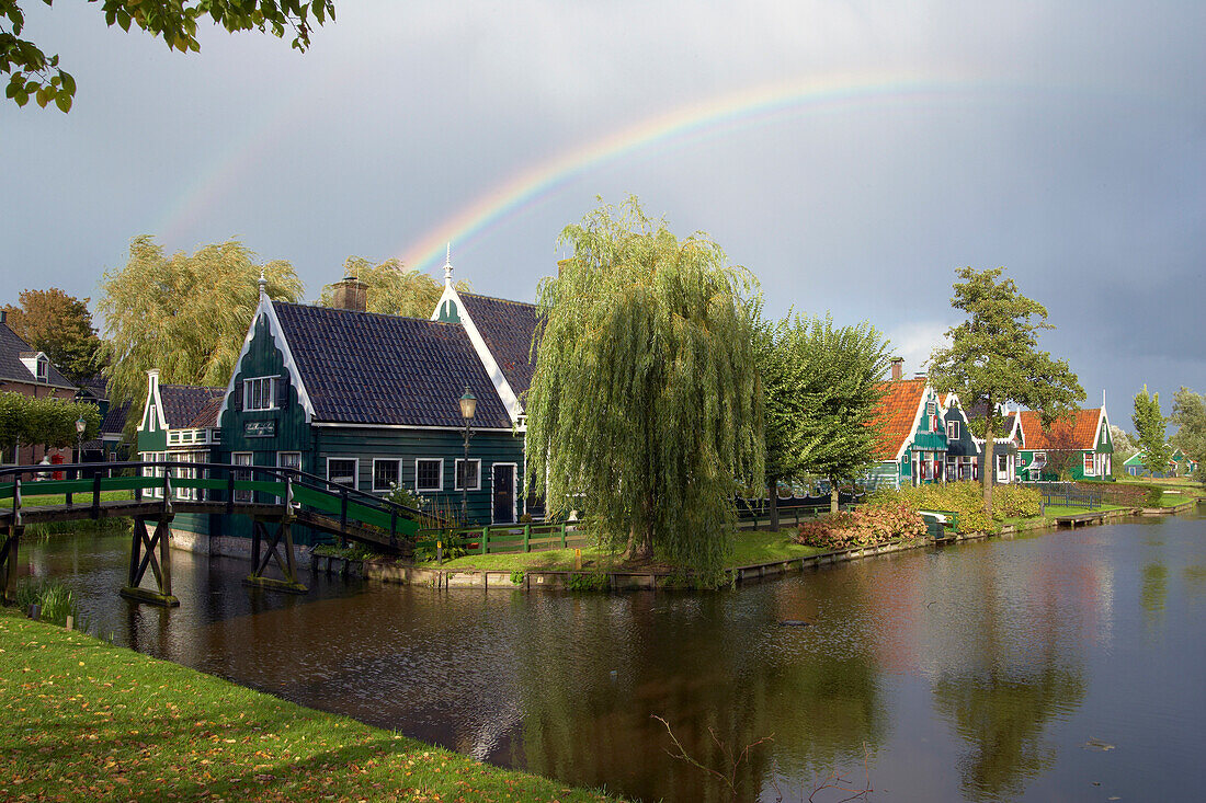 Houses at the river Zaan under a rainbow, Open-air museum Zaanseschans, Netherlands, Europe