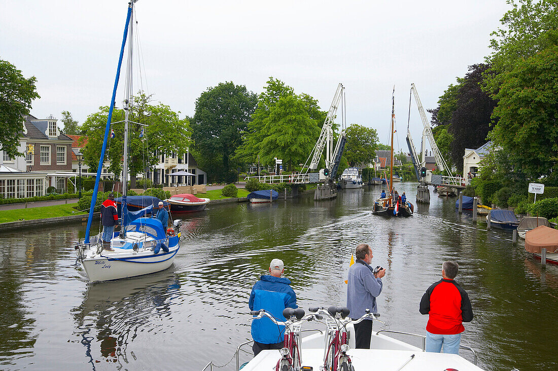 Sailing boats on the river Vecht driving past a bascule bridge, Netherlands, Europe