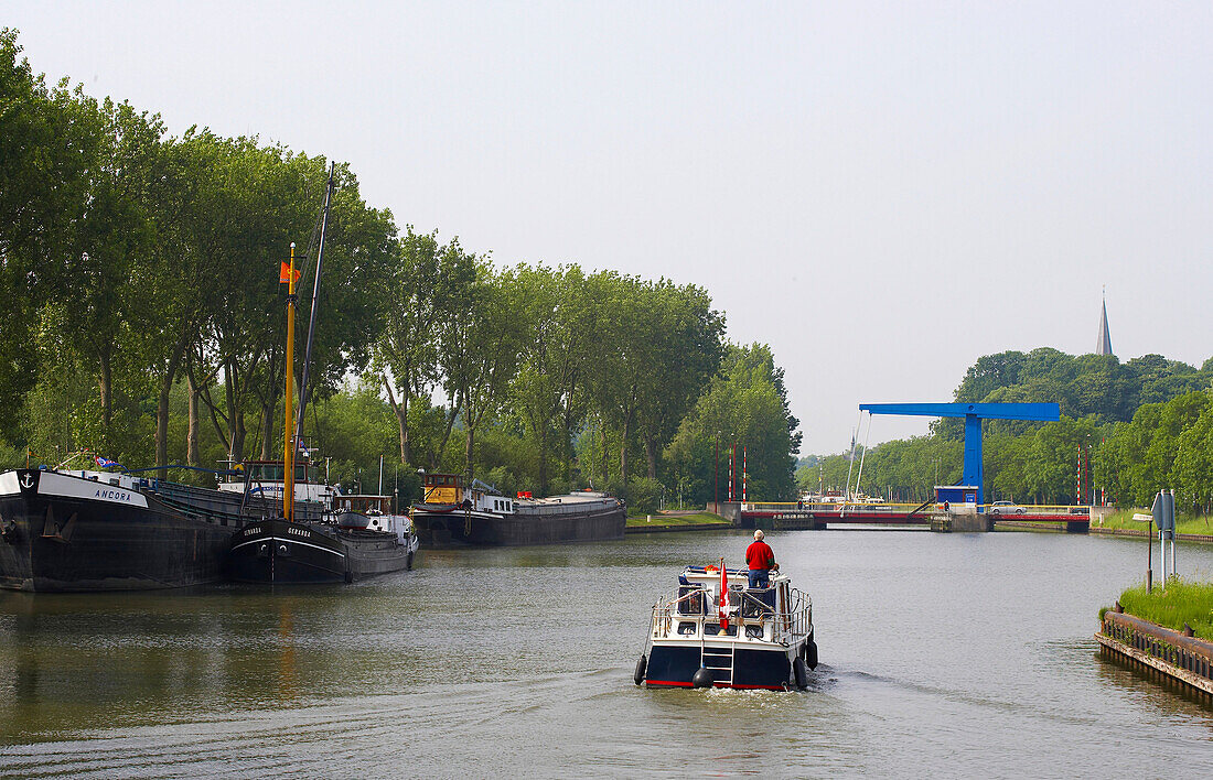 Ein kleines Boot auf dem Merwede Kanal nähert sich einer Klappbrücke, Holland, Europa