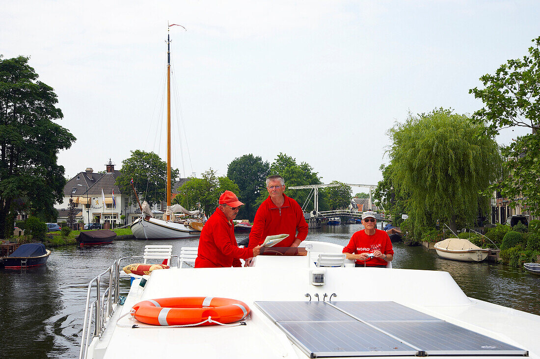 Menschen fahren mit dem Hausboot auf dem Fluss Vecht in Vreeland, Niederlande, Europa
