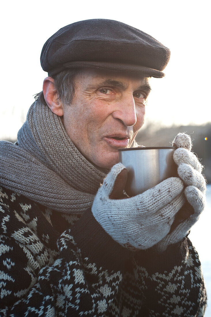 Alter Mann hält einen Becher, Ammersee, Oberbayern, Deutschland