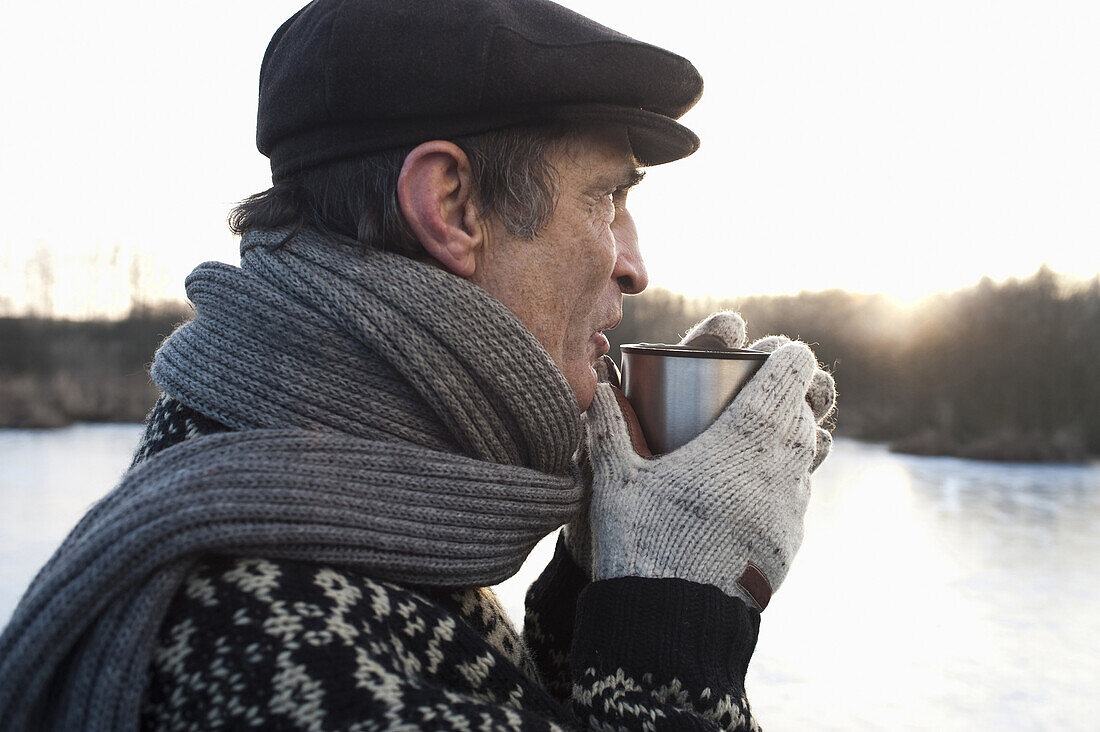 Senior man holding a cup, Lake Ammersee, Upper Bavaria, Germany