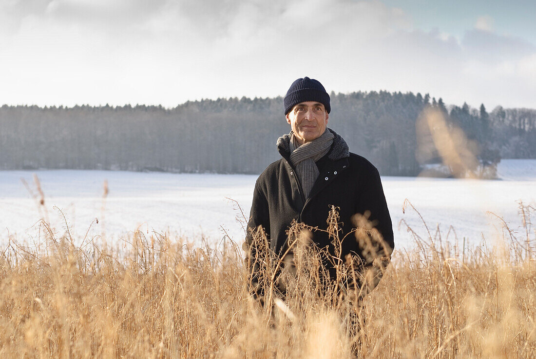 Senior man standing in winter scenery, Windach, Upper Bavaria, Germany