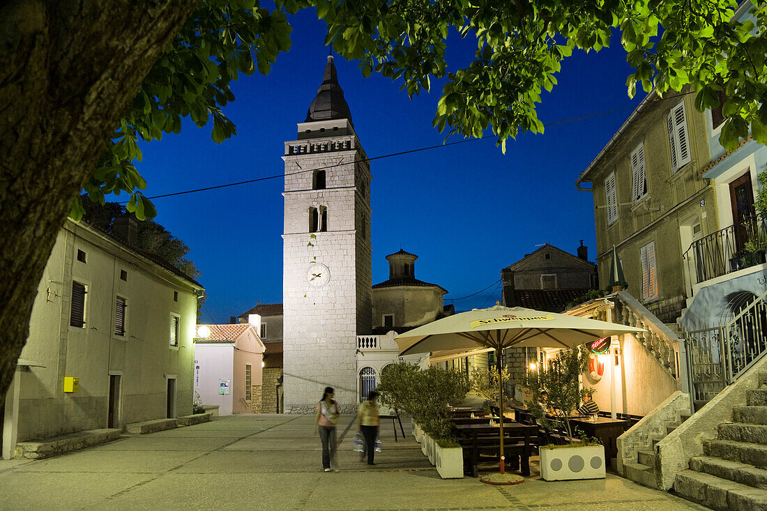 Ein Paar geht abends über den Marktplatz, Omisalj, Insel Krk, Istrien, Kroatien, Europa